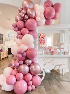 the balloon column is decorated with pink, white and silver balloons for an elegant birthday party