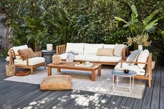 an outdoor living room with wooden furniture and plants