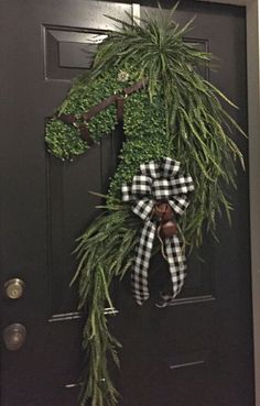 the front door is decorated with an evergreen wreath and monogrammed letter f on it