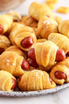 hot dogs wrapped in croissants on a plate