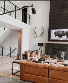 a living room filled with furniture and a fire place next to a stair case in front of a window