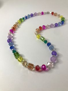 A rainbow of a necklace to brighten your life. The details are: - Rainbow - No more than 46 cm in length  - Nonadjustable - Made with glass and plastic beads - Only one of its kind! These elegant jewelry pieces consist of various glass bead creations with stainless steel, hematite, and other materials.  Want to see more similar creations? Visit https://www.etsy.com/people/ck0raz5mun8061t9?ref=hdr_user_menu-profile for more! Rainbow Faceted Beads Necklace For Gift, Adjustable Rainbow Crystal Necklace With Faceted Beads, Adjustable Rainbow Faceted Beads Necklace, Rainbow Crystal Necklaces With Colorful Beads For Gift, Adjustable Rainbow Necklace With Colorful Beads, Iridescent Necklaces With Colorful Beads As A Gift, Iridescent Necklaces With Colorful Beads For Gifts, Multicolor Glass Beaded Crystal Necklaces, Iridescent Necklace With Colorful Beads For Gift