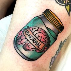 a person with a tattoo on their leg that has a jar filled with flowers in it