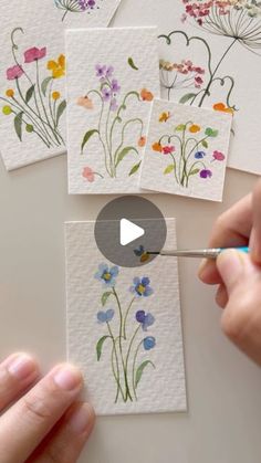 someone is painting flowers with watercolors on paper