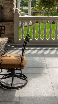 a rocking chair sitting on top of a patio next to a table and chairs under a gazebo