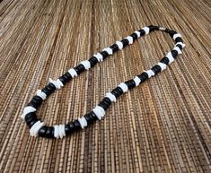 "Black and White Puka shell Necklace. Handmade with white seashell and black wooden beads 17\" Inches Around the neck Handmade Design. Necklace is Unisex Fits Most Sizes FAST SHIPPING! *First Class Mail* Visit my Etsy Shop to see more Designs! Handmade Earrings, Puka Shell Bracelets and Puka Shell Necklaces. Click here to see more designs: https://www.etsy.com/shop/FreedomLifeStyle" Black Beaded Necklace For Vacation, Black Wooden Beads Necklace For Beach, White Necklace With Black Beads For Beach, Black Round Bead Jewelry For Vacation, Black Round Beads Jewelry For Vacation, White Wooden Beads Necklace For Vacation, Black Round Bead Jewelry, Handmade Black Shell Necklaces, Adjustable Black Necklace For Vacation