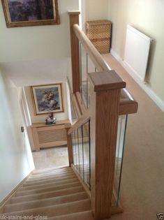 a staircase with wooden handrails and glass balconies in an empty house