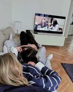 two people sitting on the floor watching television