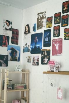 a room with posters on the wall and bookshelf in front of it's shelves