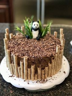 a cake decorated with bamboo sticks and a panda figurine sitting on top of it