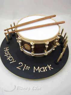 a birthday cake made to look like a drum and drumsticks on top of it