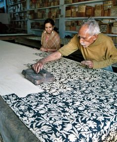 an old man and woman are working in a shop