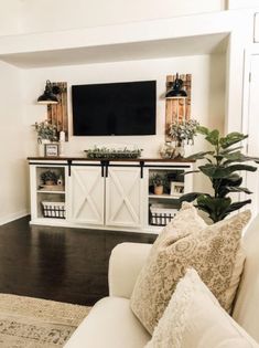 a living room filled with furniture and a flat screen tv mounted to the side of a wall