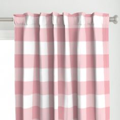 a pink and white checkered curtain hanging from a window