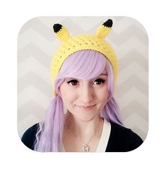 a woman with long purple hair wearing a yellow knitted pika - poo hat