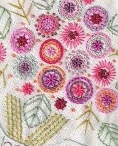 a close up view of the embroidery on a piece of cloth with flowers and leaves