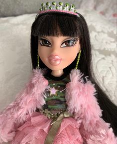 a close up of a doll wearing a tiara