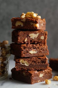 a stack of brownies with walnuts on top