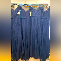 four blue dresses hanging up in a closet