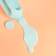 a blue toothbrush on an orange background with the top half cut out to show it's teeth