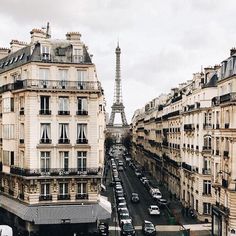 black and white photograph of the eiffel tower in paris, with cars parked on the street