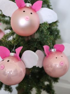 pink ornaments hanging from a christmas tree with angel wings on it's ears and nose