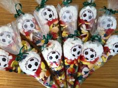 a bunch of candy wrapped in plastic bags with soccer themed candies on top of them