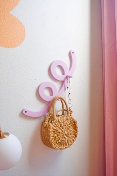 there is a purse hanging on the wall next to a letter shaped key holder that says love