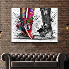 a living room with a couch and a painting on the wall above it that has colorful shoes