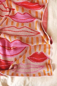 an orange and pink blanket with lips on it