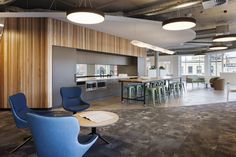 an office with chairs, desks and bar stools in front of the counter