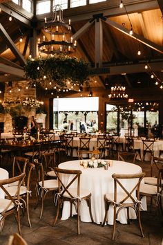 an indoor venue with tables and chairs set up for a wedding reception at the lodge