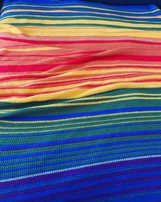 a multicolored crocheted blanket sitting on top of a bed