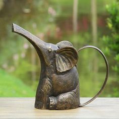 an elephant statue sitting on top of a wooden table