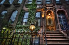 an old building with ivy growing on it's side and stairs leading up to the door