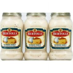 three jars of bertolli alfredo sauce on a white background