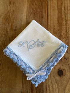 a blue and white embroidered handkerchief on top of a wooden table