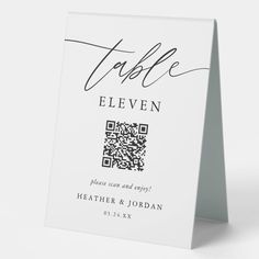 a white table card with the word table eleven printed on it and a qr code