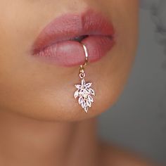 a close up view of a woman's nose wearing gold earrings with white flowers on them