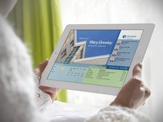 a woman is holding up a tablet displaying the company's website