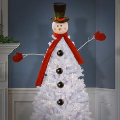 a white christmas tree with a snowman on top