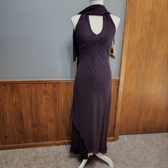 a mannequin wearing a purple dress with beading on the neck and shoulders