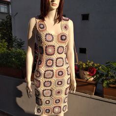 a mannequin wearing a crocheted dress in the sun