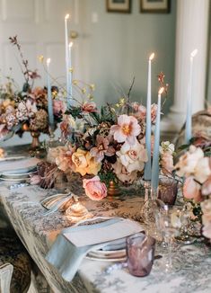 the table is set with flowers and candles for an elegant dinner party or wedding reception