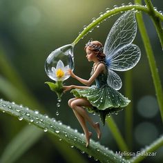 a fairy figurine sitting on top of a leaf next to a water drop