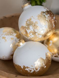 white and gold ornaments in a wooden bowl