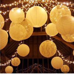 white paper lanterns are hanging from the ceiling