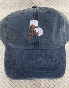 Cotton branches are in this season! Perfect for the southern belle trying to keep the sun and messy hair out of her face! Hat pictured is Navy. These hats are Adams brand. They are 100% cotton twill, garment washed and pigment dyed. These are a low profile with a mesh lining. The back has a tuck-away leather strap with a brass buckle. (seen in picture #4) Hat colors available in picture #2. NEW Spring/Summer hat colors available in picture #3. (Neon Pink, Neon Yellow, Neon Green, Tangerine) Casual Brimmed Hat With Embroidered Logo, Cotton Brimmed Dad Hat For Beach, Trendy Brimmed Cotton Baseball Cap, Cotton Brimmed Hat With Embroidered Logo, Vintage Cotton Dad Hat One Size, Vintage Cotton Baseball Cap For Summer, Vintage Cotton Dad Hat One Size Fits Most, Cotton Brimmed Trucker Hat For Summer, Summer Cotton Brimmed Trucker Hat