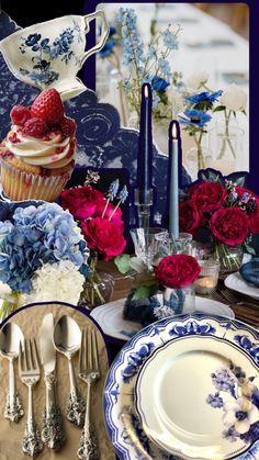 the table is set with blue and white plates, silverware, red roses, and cupcakes