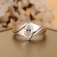 a white diamond ring sitting on top of a table